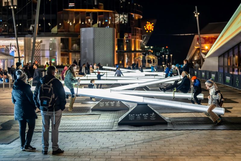 People playing on seesaws in the evening in Downtown DSM