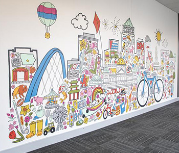 Paint-by-Numbers A painted mural with several landmarks from across Des Moines like the butter cow, food and drink and more.